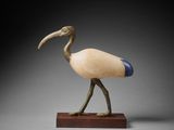 wooden sculpture of a bird with a long beak on a wooden base