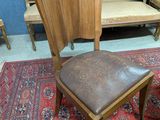 une chaise en bois avec une assise en cuir dans une pièce