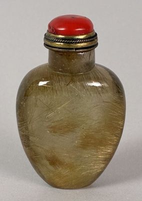 a glass vase with a red lid sitting on a table