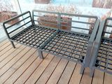 deux lits métalliques posés sur un plancher en bois