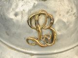 a silver helmet with a gold letter b on it