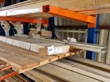 une grande pile de planches de bois posées sur une palette dans un entrepôt