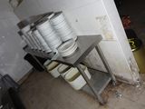 de nombreuses assiettes empilées sur une étagère métallique dans la cuisine