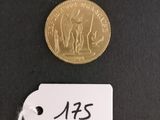 a small gold coin with a tag on it