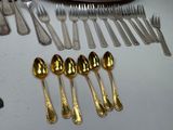 a lot of silver spoons and silverware on a table