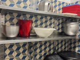many pots and pans on the shelves in the kitchen