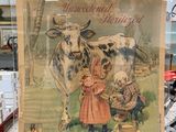 une affiche sur laquelle on peut lire « lait idéal » et qui représente une femme en train de traire une vache
