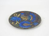 a small plate with a bird on it on a white surface