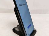 a close up of a cell phone on a stand on a white surface