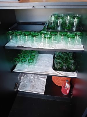 de nombreux verres verts sur les étagères de la cuisine