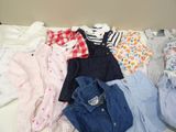 a lot of baby clothes that are on the bed