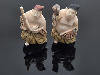 deux figurines représentant deux hommes assis sur une surface noire