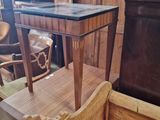 a wooden table with a black top sitting in a room