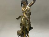 bronze statue of a woman holding a bird and a dog