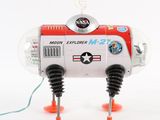 a toy robot that is sitting on top of an orange stand