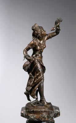 a bronze statue of a woman holding a basket on top of a rock