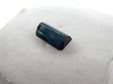 an image of a green tourmaline stone on a white surface