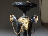 a black and gold pedestal with a lion head on it
