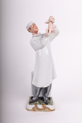 figurine en porcelaine représentant un homme tenant un bébé dans ses bras