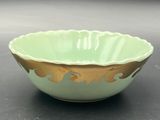 green and gold bowl on table with black background