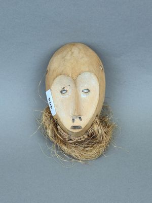 un masque en bois orné d'un nid d'oiseau