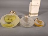 two perfume bottles and a box of perfume sitting on a table