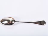 silver spoon on a white surface with a reflection of the spoon