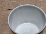 a white cup with a spoon on a wooden table