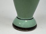 a green vase that is sitting on a white table