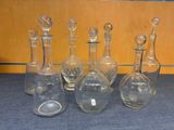 five glass decantes sitting on a table next to each other