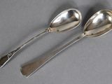 two silver spoons and a spoon with a handle on a gray surface