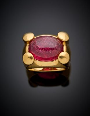 a close up of a gold ring with a ruby stone