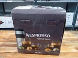 une boîte contenant des machines à café Nespresso Vertuo Plus posée sur une table