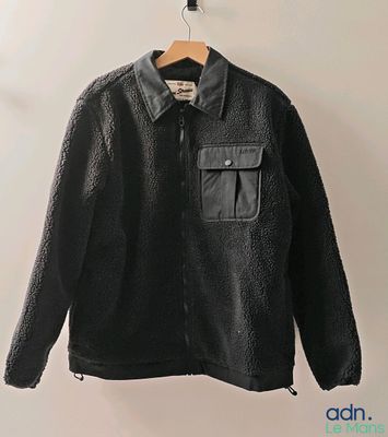 la veste est suspendue à un cintre sur le mur