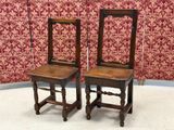two wooden chairs sitting next to each other on the floor