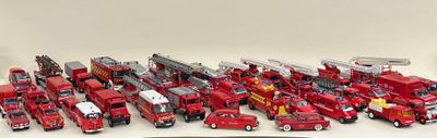 tout un tas de camions de pompiers miniatures posés sur une table
