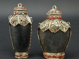 paire de vases noirs et dorés ornés de pierres rouges et bleues