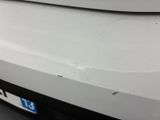 the front bumper of a white car with scratches on it