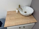 a sink and a trash can in a small bathroom