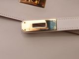 a close up of a white purse with a gold buckle