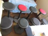 plusieurs tabourets noirs avec des assises rouges dans une pièce où se trouve un lit