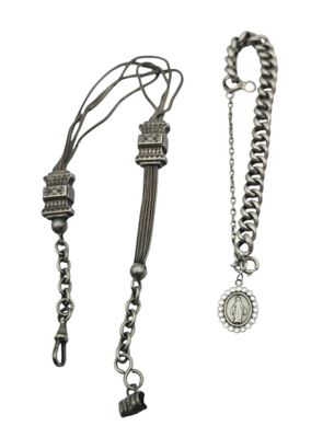 deux bijoux en argent sur fond blanc, accompagnés d'une chaîne