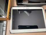 une tablette posée sur une table à côté d'autres appareils électroniques