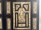a black and gold decorated cabinet with a picture of a woman
