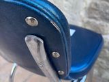an image of a blue chair against a stone wall