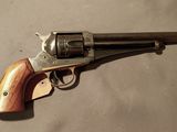 un vieux revolver avec une poignée en bois sur une surface blanche