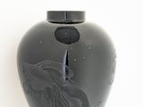 a black vase sitting on a white table