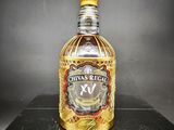 une bouteille de Chivas Regal XO posée sur une table noire