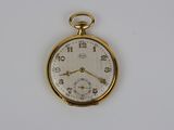 une montre de poche en or sur une surface blanche