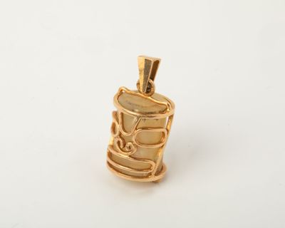 a close up of a gold pendant on a white surface